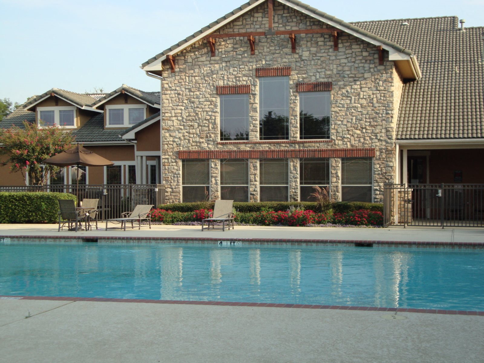 Building exterior with swimming pool, tanning deck, and clubhouse exterior